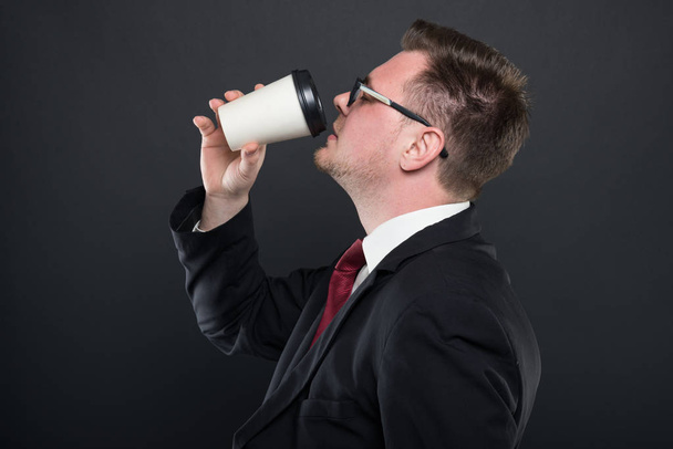 Вид збоку на ділового чоловіка, який п'є каву
 - Фото, зображення