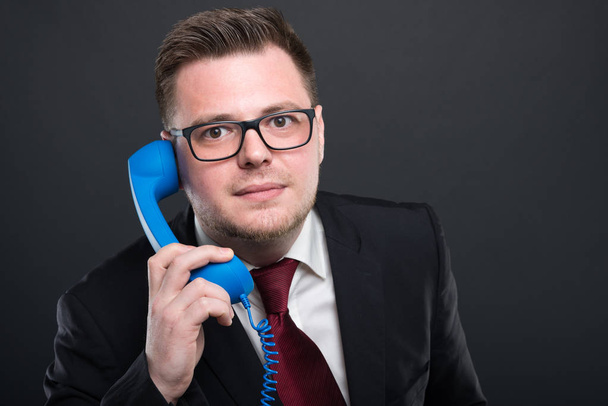Business young man holding  blue telephone receive - Фото, зображення