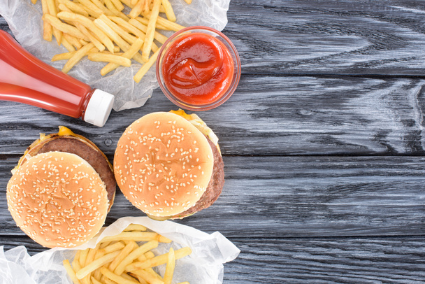 vista superior de hambúrgueres com batatas fritas e ketchup na mesa de madeira
     - Foto, Imagem