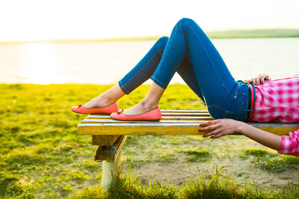 no face. unrecognizable person. Attractive female legs on the bench at the beach. - Foto, Imagen