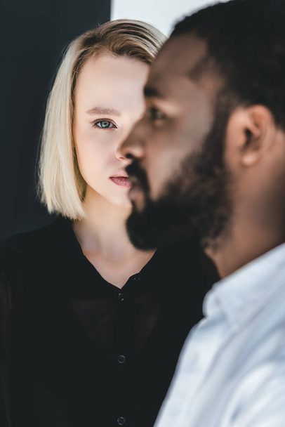 side view of african american boyfriend standing in front of blonde girlfriend - Fotografie, Obrázek