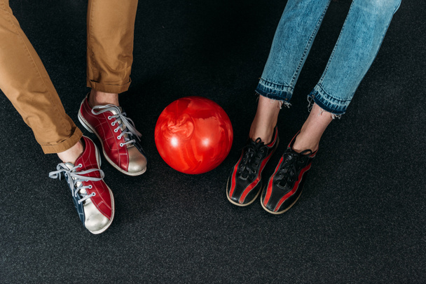обрезанный снимок пары в арендованной обуви для боулинга с мячом
 - Фото, изображение