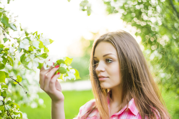 woman standing near the apple tree on a warm summer sunny day  - Foto, imagen