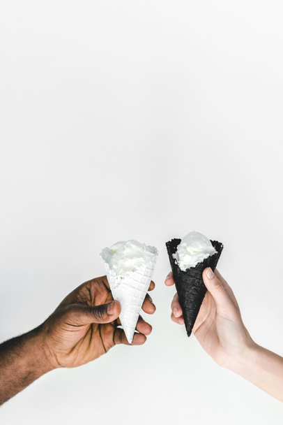 imagem cortada de namorado americano africano e namorada clinking com cones de sorvete isolado em branco
 - Foto, Imagem