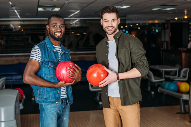 Happy mladíci s míčky v bowling Clubu při pohledu na fotoaparát - Fotografie, Obrázek