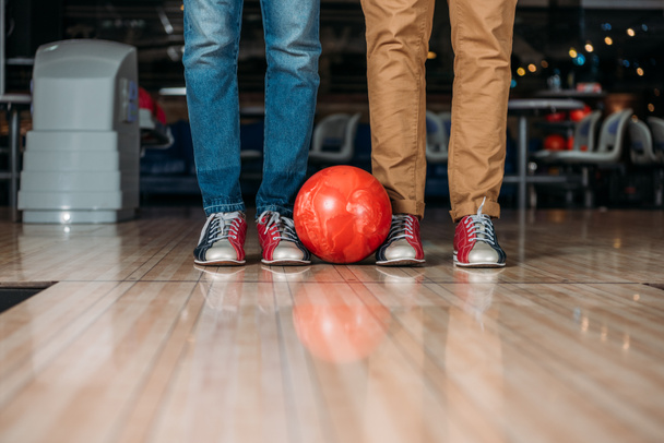 plan recadré d'hommes debout devant une piste de bowling avec balle
 - Photo, image