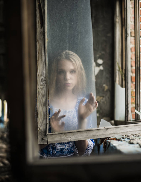 portrait of Young adult woman near dirty glass window.  - Valokuva, kuva