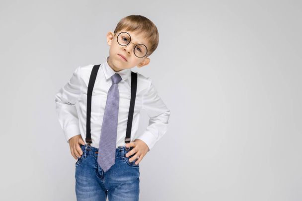 Portrait d'adorable petit garçon sérieux confiant dans des lunettes sur fond gris
 - Photo, image