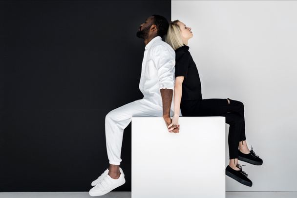 Multikulturelles Paar hält Hand an White Cube, Yin Yang Konzept - Foto, Bild