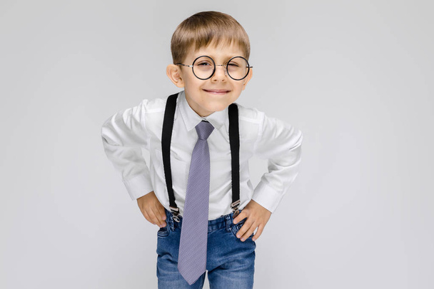 Portrait of adorable serious confident little boy in glasses on grey background - Fotoğraf, Görsel