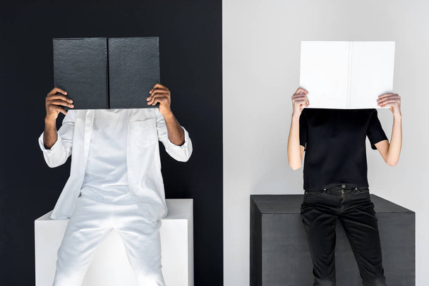 african american boyfriend and girlfriend covering faces with books - Foto, immagini