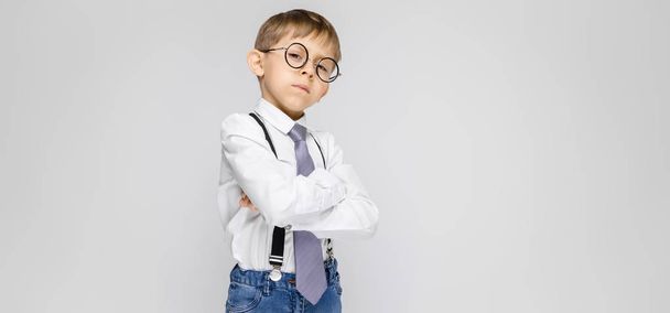 Porträt eines entzückenden kleinen Jungen mit Brille auf grauem Hintergrund - Foto, Bild