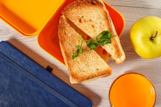 Желтая коробка для сэндвичей с поджаренными ломтиками хлеба, сыра и гра
 - Фото, изображение