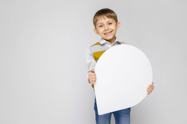 Portrait d'adorable petit garçon tenant une épinglette de carte sur fond gris
 - Photo, image