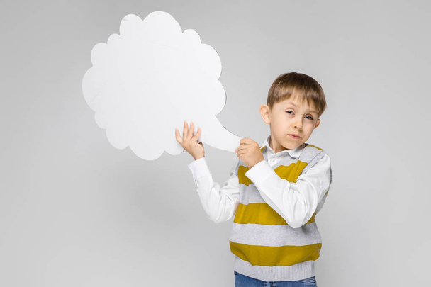 Πορτρέτο του αξιολάτρευτο μικρό αγόρι κρατώντας ομιλία σύννεφο σε γκρίζο φόντο - Φωτογραφία, εικόνα