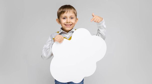 Suloisen pojan muotokuva pitämässä puhepilveä harmaalla pohjalla
 - Valokuva, kuva