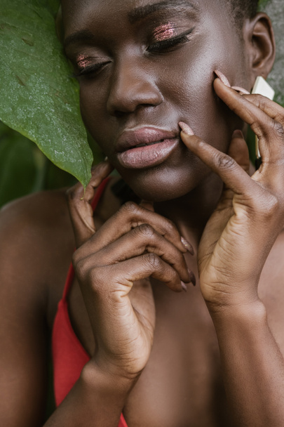 portrait of tender african american girl posing with glitter makeup   - Foto, imagen