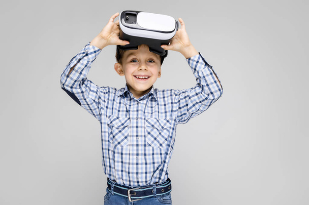 Портрет восхитительного мальчика в VR-очках на сером фоне
 - Фото, изображение