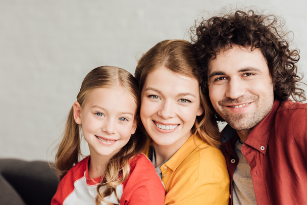 portrait of beautiful happy young family smiling at camera - Fotó, kép