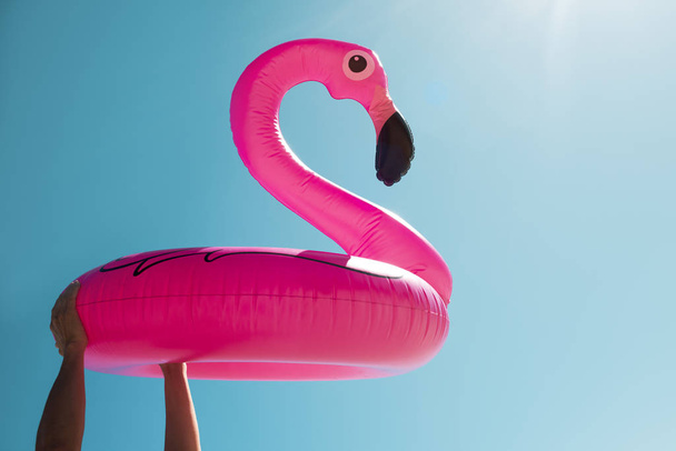 man with a pink flamingo swim ring - Photo, image