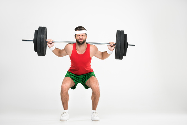 sportsman in retro sportswear squating with barbell, isolated on white - Foto, immagini