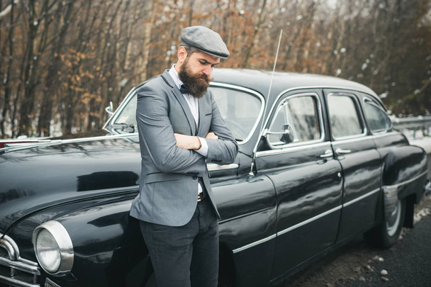 Call boy in vintage auto. Bearded man in car. Escort man or security guard. Retro collection car and auto repair by mechanic driver. Travel and business trip or hitch hiking - Photo, Image