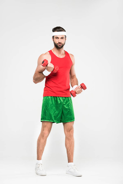 handsome sportsman in retro sportswear training with dumbbells, isolated on white - Photo, Image