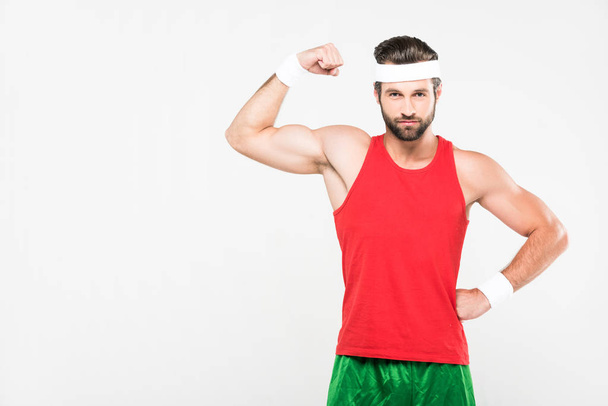 muskulöser Sportler posiert in Retro-Sportbekleidung, isoliert auf weiß - Foto, Bild