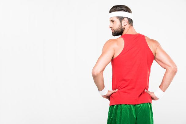 вид сзади спортсмена, позирующего в ретро спортивной одежде, изолированного на белом
 - Фото, изображение