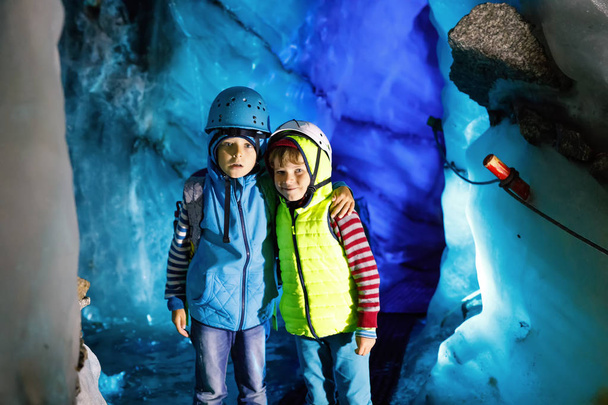 Due ragazzini con caschi di sicurezza e abbigliamento con paesaggi montani. Escursioni per bambini e scoperta del ghiacciaio in Tirolo, Austria, Hintertux
 - Foto, immagini