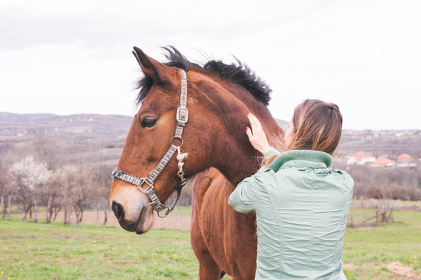 Krásná mladá žena na ranči těsně spjatém s hnědý kůň - Fotografie, Obrázek