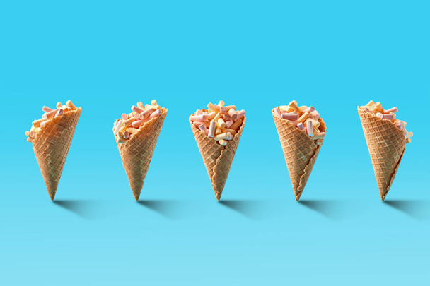 Palomitas de maíz en conos de helado sobre fondo azul
. - Foto, imagen