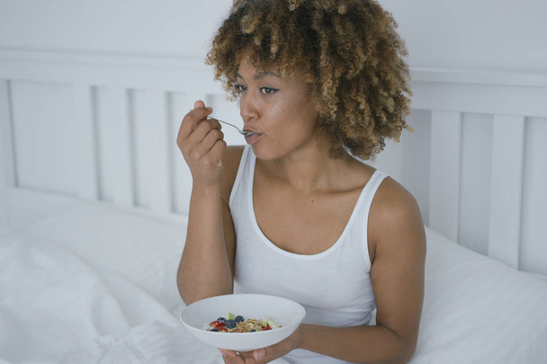 fiatal nő eszik reggelit az ágyban - Fotó, kép