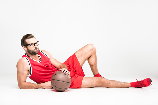 sportsman in red sportswear posing with basketball ball, isolated on white - Photo, Image