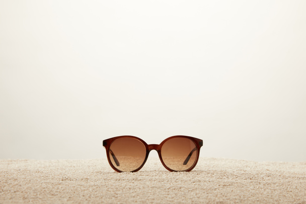 vue rapprochée des lunettes de soleil sur sable sur fond gris
 - Photo, image