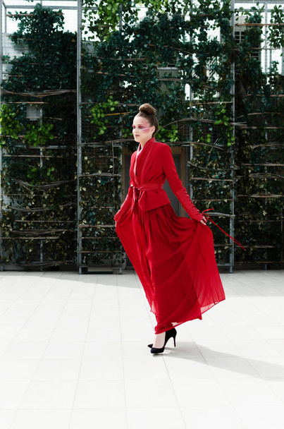 young model in designer long red dress posing on roof - 写真・画像