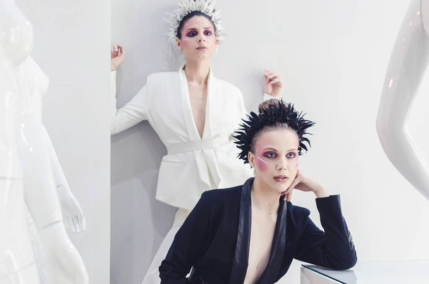Two fashionable women in designer clothes posing in studio - Foto, imagen