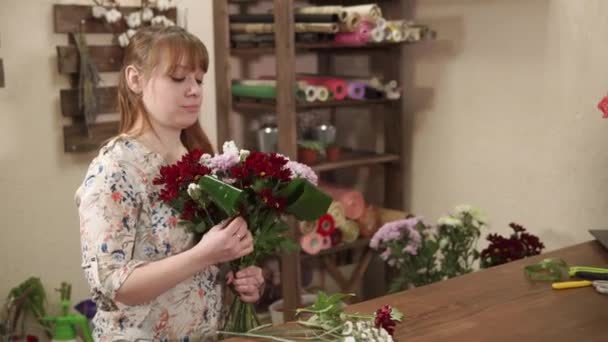 Mädchen bereitet Blumenstrauß und Grünzeug für den Handel in einem Blumenladen vor - Filmmaterial, Video