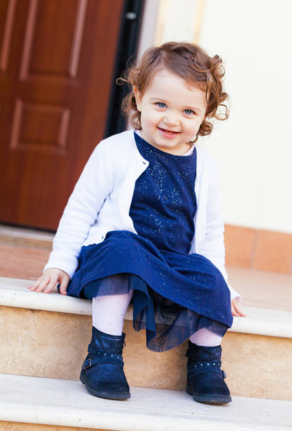 Porträt eines schönen kleinen Mädchens auf der Treppe - Foto, Bild