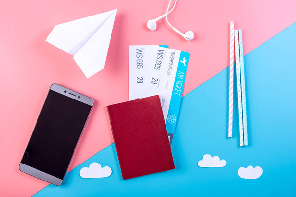 Flugtickets mit Reisepass und Papierflugzeug auf pastellfarbenem Hintergrund, Topview. das Konzept von Flugreisen und Urlaub - Foto, Bild