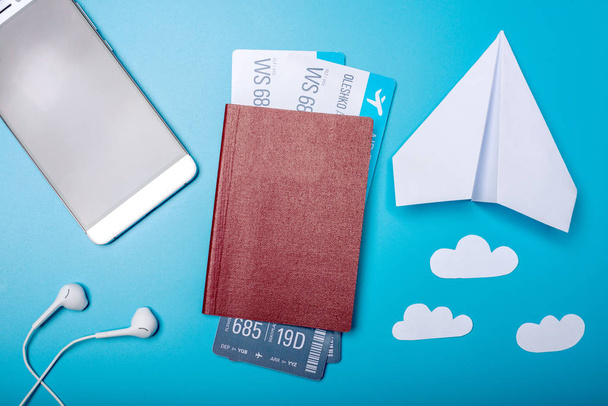 Flugtickets mit Reisepass und Papierflugzeug auf blauem Hintergrund, Draufsicht. das Konzept von Flugreisen und Urlaub - Foto, Bild