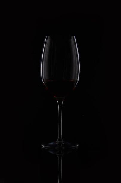 closeup shot of glass with red wine isolated on black background - Photo, image