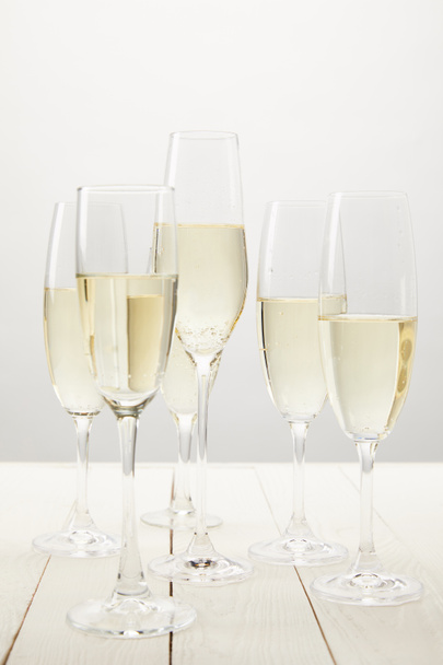 closeup view of champagne glasses on white wooden table  - Foto, Bild