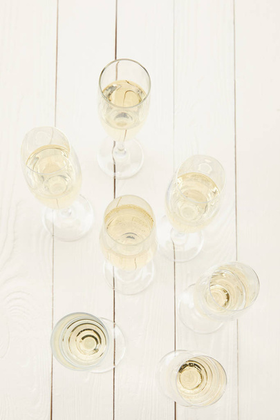 top view of champagne glasses on white wooden table  - Foto, Bild