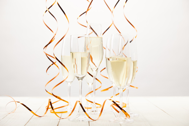 champagne glasses with ribbons on white wooden table, holiday concept  - Photo, Image