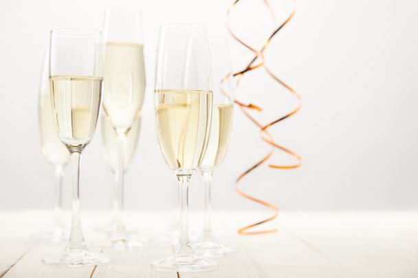 close up view of champagne glasses with ribbons on white wooden table, holiday concept  - Photo, Image
