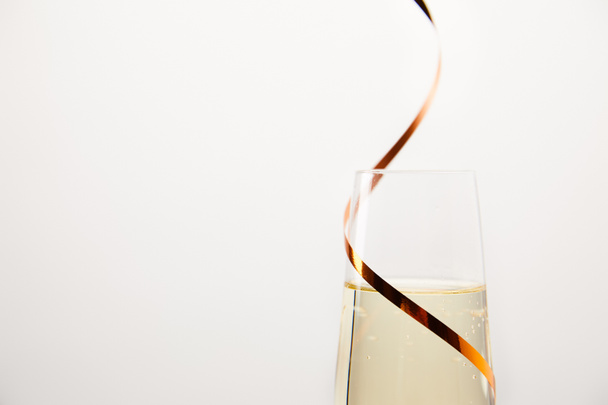 白い背景に、休日の概念に分離されたリボンで包まれたシャンパン グラスのショットを閉じる  - 写真・画像