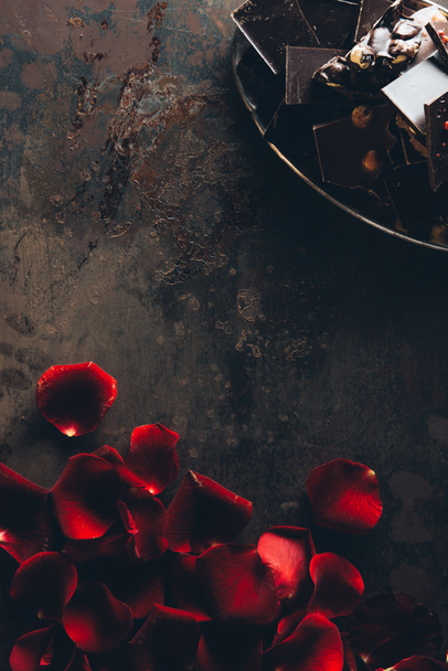 hermosos pétalos de rosa roja y trozos de chocolate gourmet con nueces
   - Foto, imagen