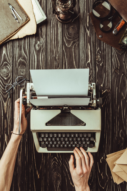 částečný pohled spisovatele rukou, psaní stroj a obálky na dřevěnou desku - Fotografie, Obrázek