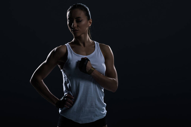 hermosa deportista fuerte posando en ropa deportiva, aislado en negro
    - Foto, Imagen